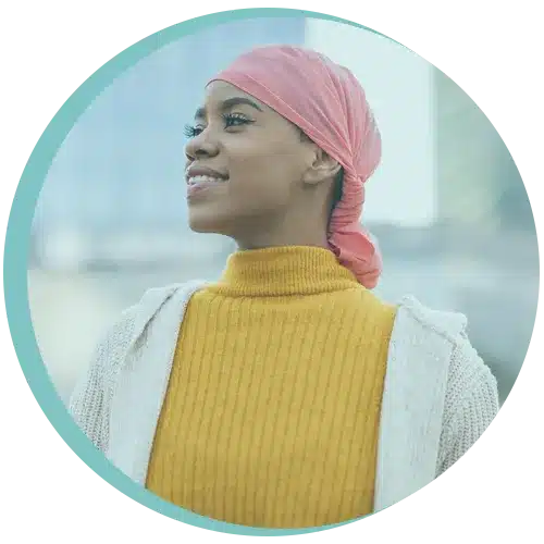 Woman in headscarf smiling confidently after breast cancer physiotherapy in London