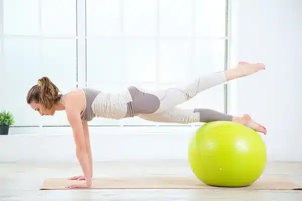 Woman performing pelvic floor rehabilitation exercises with physiotherapy support