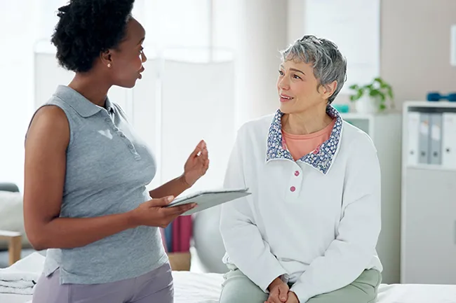 Physiotherapist discussing pelvic organ prolapse assessment with a woman during a consultation in a London clinic