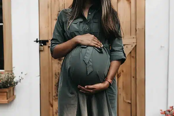 Pregnant woman holding her bump during pregnancy support and women’s health care