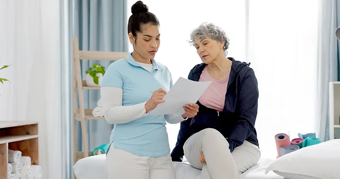 Pelvic health physiotherapist discussing menopause pelvic floor symptoms with a woman in a Central London clinic