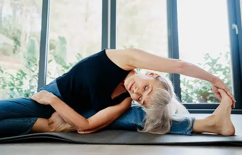 Woman performing stretching exercise that supports pelvic floor health and prolapse physiotherapy treatment in London